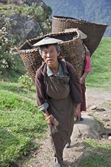 Women with large bamboo baskets go to collect produce from their hillside farms in the Mangde Chhu Valley Women with large bamboo baskets go to collect produce from their hillside farms in the Mangde Chhu Valley
