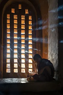 Prints of A young monk studying by a window inside a temple, UNESCO, Bagan, Mandalay Region, Myanmar Myanmar Prints: A Young Monk Studies by a Window in Bagan Temple Print