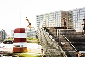 Young people diving into a swimming pool in a water canal in Copenhagen, Denmark Young people diving into a swimming pool in a water canal in Copenhagen, Denmark
