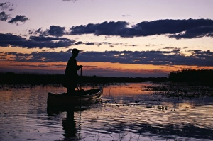 Zambia Game scout poling mokorro along Lukulu River at sunset Zambia Game scout poling mokorro along Lukulu River at sunset