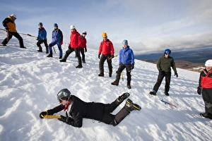 A group of mountaineers practice ice axe arrests on Cairngorm in the Cairngorm National Park in Scotland A group of mountaineers practice ice axe arrests on Cairngorm in the Cairngorm National Park in Scotland