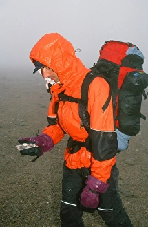 A mountaineer navigating in the Cairngorm mountains in the mist and rain in Scotland A mountaineer navigating in the Cairngorm mountains in the mist and rain in Scotland