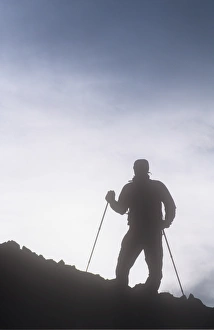 A mountaineer using wallking poles in the Lake District, UK A mountaineer using wallking poles in the Lake District, UK