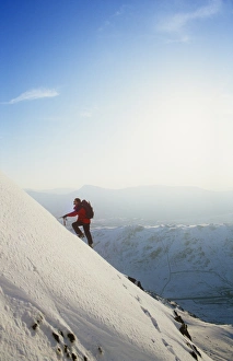 A mountaineer winter climbing on Red Screes in the Lake district, UK A mountaineer winter climbing on Red Screes in the Lake district, UK