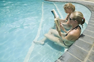Women reading books in a swimming pool at the Walu Beach Resort on Malolo Island off Fiji Women reading books in a swimming pool at the Walu Beach Resort on Malolo Island off Fiji