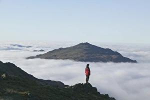 A women walker looking towards Harter Fell in the Lake district above the cloud A women walker looking towards Harter Fell in the Lake district above the cloud