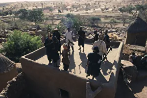 MALI People Dogon Members of ancient Dogon society performing rooftop dance holding MALI People Dogon Members of ancient Dogon society performing rooftop dance holding
