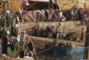 MOROCCO Essaouira Busy port scene with moored fishing boat and crowds on stone quay MOROCCO Essaouira Busy port scene with moored fishing boat and crowds on stone quay