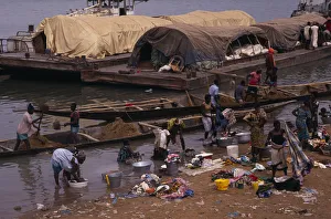 SENEGAL, Niger River Women washing clothes in river from bank with barges SENEGAL, Niger River Women washing clothes in river from bank with barges