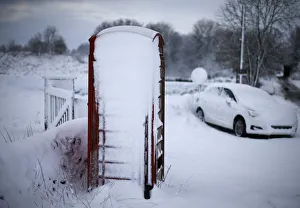 An abandoned car and a telephone box stand in snow near Ashbourne An abandoned car and a telephone box stand in snow near Ashbourne