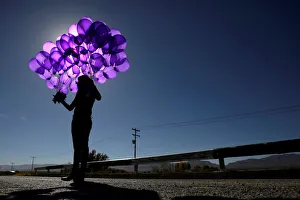 Activist holds purple balloons at El Navajo creek during a ceremony to mark the Activist holds purple balloons at El Navajo creek during a ceremony to mark the