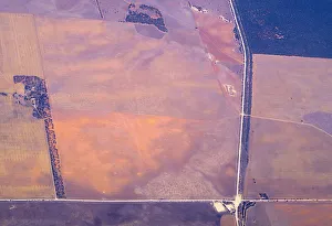 An aerial view of a house and intersecting roads amongst agricultural farming land An aerial view of a house and intersecting roads amongst agricultural farming land