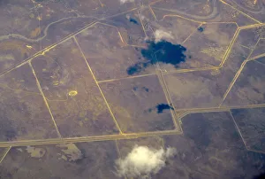 An aerial view of intersecting roads and dams amongst agricultural farming land in An aerial view of intersecting roads and dams amongst agricultural farming land in
