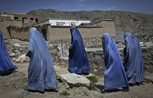 Afghan women clad in burqa walk up a hill at the old part of Kabul Afghan women clad in burqa walk up a hill at the old part of Kabul
