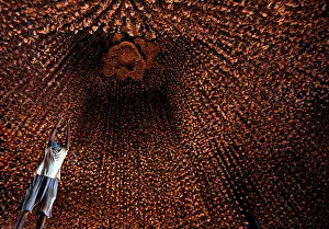 An artisan hangs decorative pieces at a pandal, or a temporary platform, for the upcoming An artisan hangs decorative pieces at a pandal, or a temporary platform, for the upcoming