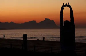 An athlete stretches in front of Recreio dos Bandeirantes beach before the Rio de An athlete stretches in front of Recreio dos Bandeirantes beach before the Rio de