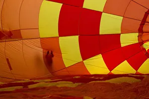 An attendee touches the outside of an inflating hot air balloon during the 2015 An attendee touches the outside of an inflating hot air balloon during the 2015