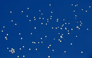 Balloons fly after being released by people who gather to commemorate the victims of a Balloons fly after being released by people who gather to commemorate the victims of a