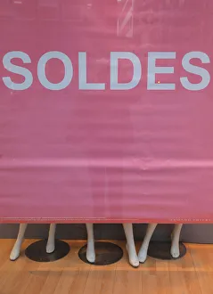 A banner announces Sales on a clothing store front window during the start of winter A banner announces Sales on a clothing store front window during the start of winter
