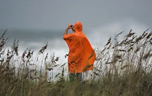 A beach goer photographs the storm surf from the dunes a day before the landfall of A beach goer photographs the storm surf from the dunes a day before the landfall of
