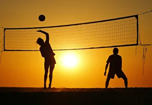 Beachgoers play volleyball at the beach as the sun sets in Carlsbad, California Beachgoers play volleyball at the beach as the sun sets in Carlsbad, California