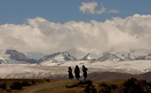 BOLIVIAN WOMEN AYMARAS WALK ON HIGHWAY BY ILLAMPU MOUNTAIN RANGE BOLIVIAN WOMEN AYMARAS WALK ON HIGHWAY BY ILLAMPU MOUNTAIN RANGE