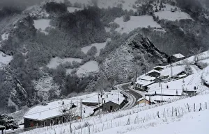 A car crosses the village of Pajares covered by snow A car crosses the village of Pajares covered by snow