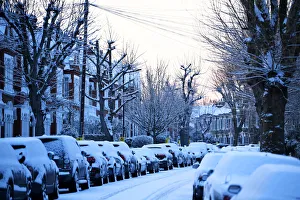 Cars are seen on a snow covered street in South London Cars are seen on a snow covered street in South London