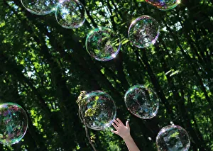 A child plays with soap bubbles at an event to support autistic children and their A child plays with soap bubbles at an event to support autistic children and their
