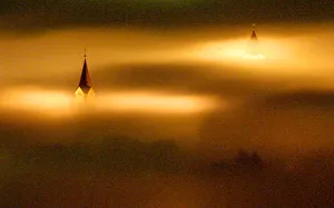 CHURCH TOWERS PEAK THROUGH HEAVY NIGHT TIME FOG IN LIPTOVSKY MIKULAS CHURCH TOWERS PEAK THROUGH HEAVY NIGHT TIME FOG IN LIPTOVSKY MIKULAS