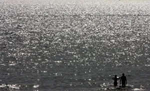 A couple is silhouetted as seeking relief from soaring temperatures at the beach in Ostia A couple is silhouetted as seeking relief from soaring temperatures at the beach in Ostia