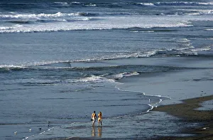A couple walk along the beach during relatively warm weather in Encinitas A couple walk along the beach during relatively warm weather in Encinitas