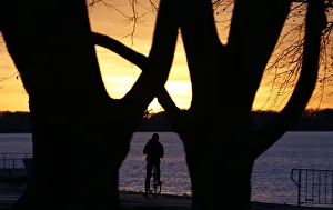 A cyclist looks at sunset from the shore of lake Tegel in Berlins Reinickendorf district A cyclist looks at sunset from the shore of lake Tegel in Berlins Reinickendorf district