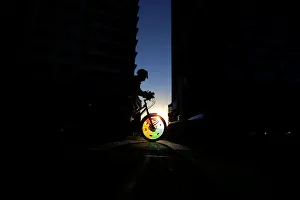 A cyclist rides into a shaft of light between two buildings in Sydneys business district A cyclist rides into a shaft of light between two buildings in Sydneys business district