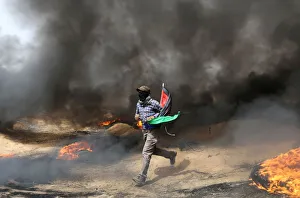 Demonstrator runs during clashes with Israeli troops at a protest where Palestinians Demonstrator runs during clashes with Israeli troops at a protest where Palestinians