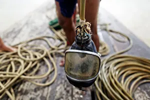 A diver holds his mask on a small boat on Yangon River after searching for coal A diver holds his mask on a small boat on Yangon River after searching for coal