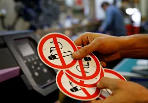 An employee shows no smoking signs in the Karas printing shop in Vienna An employee shows no smoking signs in the Karas printing shop in Vienna