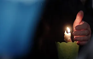 A faithful lights a candle as Pope Francis leads the Via Crucis procession during A faithful lights a candle as Pope Francis leads the Via Crucis procession during