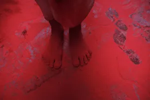 The feet of a man covered in red coloured powder are pictured during Holi celebrations in The feet of a man covered in red coloured powder are pictured during Holi celebrations in