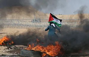 Female demonstrator carries a tire during a protest where Palestinians demand the right Female demonstrator carries a tire during a protest where Palestinians demand the right