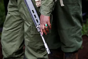 A female wildlife ranger holds a rifle during the launch of a rhino ear notching exercise A female wildlife ranger holds a rifle during the launch of a rhino ear notching exercise