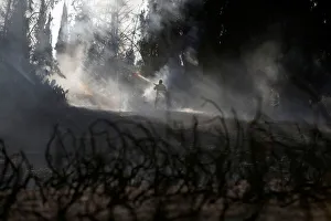 A firefighter works on the Israeli side of the border between Israel and the Gaza Strip A firefighter works on the Israeli side of the border between Israel and the Gaza Strip
