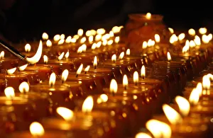 A follower lights a candle during The Grand Anniversary Memorial Prayer of Lord Jigten A follower lights a candle during The Grand Anniversary Memorial Prayer of Lord Jigten