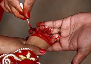 The foot of a young girl dressed as the Living Goddess Kumari is painted red as part of The foot of a young girl dressed as the Living Goddess Kumari is painted red as part of