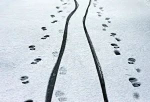 Footprints and cycle tracks are seen on a snowy road in Buxton Footprints and cycle tracks are seen on a snowy road in Buxton