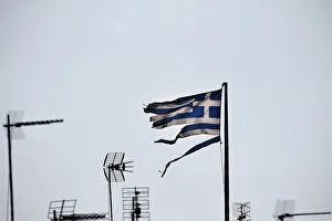 A frayed Greek national flag flutters among antennas atop a building in central Athens A frayed Greek national flag flutters among antennas atop a building in central Athens