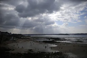 A general view of people who dot the beach as they dig for shellfish during a record low A general view of people who dot the beach as they dig for shellfish during a record low
