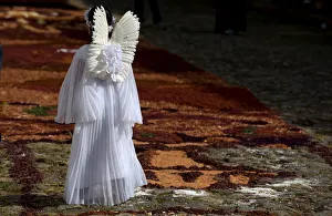 A girl dressed as an angel walks in the middle of a street decorated by residents A girl dressed as an angel walks in the middle of a street decorated by residents