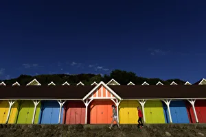 Two girls walk past beach huts in the North Bay in Scarborough Two girls walk past beach huts in the North Bay in Scarborough