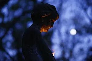 A grave monument is lit by candle light at the Powazki cemetery in Warsaw A grave monument is lit by candle light at the Powazki cemetery in Warsaw